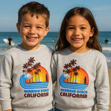 Two children wearing Hermosa Beach California sweatshirts on a beach.